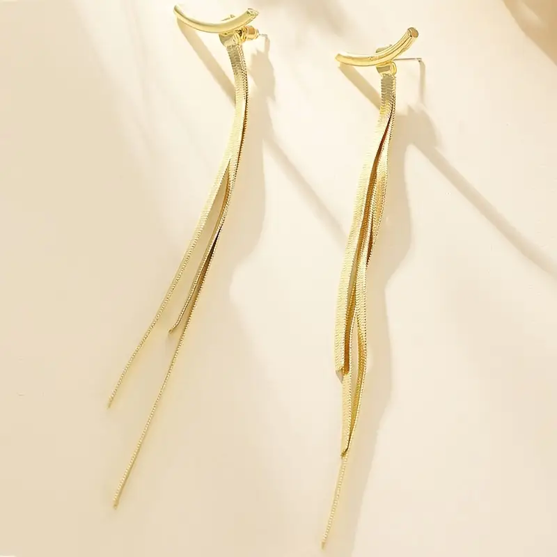 Minimalist long tassel earrings for women featuring metallic snake bone-style tassels, modern and sleek statement jewelry