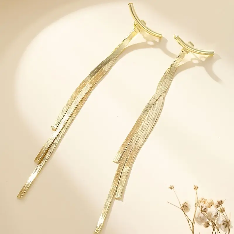 Minimalist long tassel earrings for women featuring metallic snake bone-style tassels, modern and sleek statement jewelry